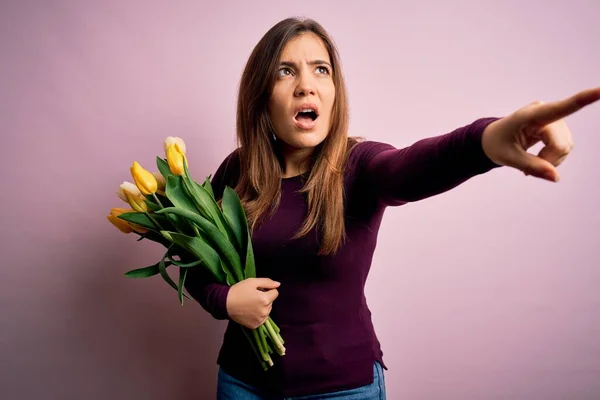 Sarı Lalelerden Oluşan Romantik Buketi Pembe Arka Planda Tutan Genç — Stok fotoğraf