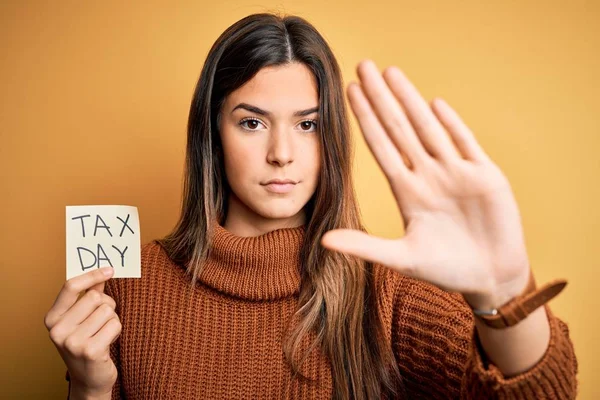 Junges Schönes Mädchen Das Mahnzettel Mit Steuertagsmeldung Über Gelbem Hintergrund — Stockfoto