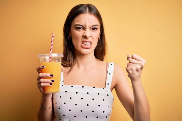 Jong Mooi Brunette Vrouw Drinken Gezond Sinaasappelsap Gele Achtergrond Geïrriteerd — Stockfoto