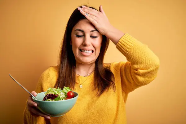 Young Beautiful Woman Eating Healthy Fresh Salad Yellow Background Stressed — Stock Photo, Image