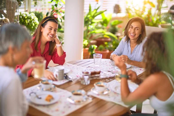 Genç ve güzel bir kız mutlu ve kendinden emin bir şekilde terasta oturmuş bir fincan kahve içiyor.