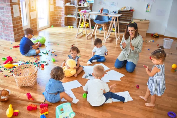 Vacker Lärare Och Grupp Småbarn Sitter Golvet Ritning Med Papper — Stockfoto