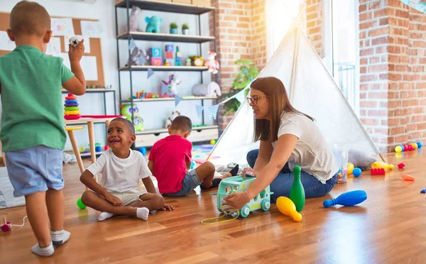 Junge Schöne Lehrerin Und Kleinkinder Spielen Kindergarten Mit Viel Spielzeug — Stockfoto