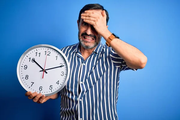 Middle Age Hoary Man Holding Big Clock Standing Isolated Blue — Stockfoto