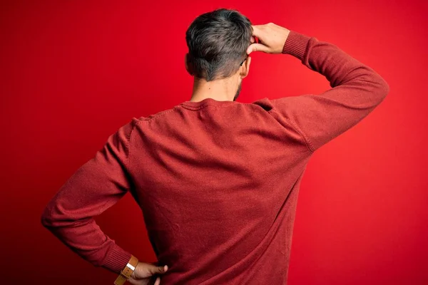 Młody Przystojny Mężczyzna Brodzie Okularach Swetrze Stojący Czerwonym Tle — Zdjęcie stockowe