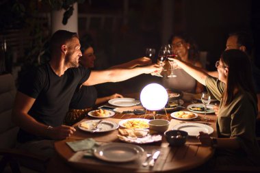Güzel bir aile terasta bir bardak şarapla kadeh kaldırıyor.