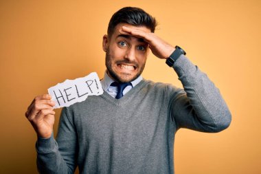 Aşırı çalışan genç iş adamı sarı zemin üzerinde kağıt tutarak yardım istiyor. Elleri başının üstünde, utanç ve şaşkınlık dolu, sinirli ve hayal kırıklığına uğramış bir halde. Hata için korku ve üzüntü.