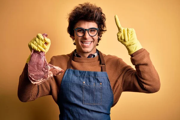 Young Handsome Butcher Man Holding Meet Steak Standing Isolated Yellow — Stockfoto