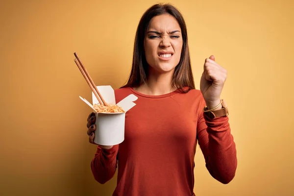 Young Beautiful Brunette Woman Eating Takeaway Noodles Using Chopsticks Annoyed — Stock Photo, Image