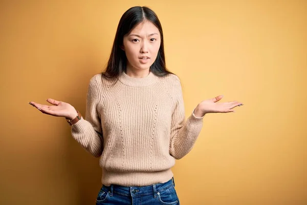 바탕에 스웨터를 아리따운 아시아 여성은 아무것도 모르는 채열린 혼란에 있었습니다 — 스톡 사진