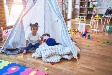 Sevimli bebekler, Tip 'in içinde, anaokulunda sırıtarak battaniyenin üzerine uzanırlar.