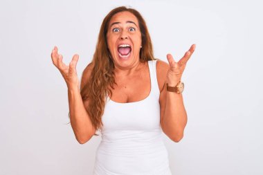 Orta yaşlı olgun bir kadın, beyaz arka planda duruyor. Kızgın ve deli gibi bağırıyor, agresif bir ifadeyle bağırıyor ve kollarını kaldırıyor. Hayal kırıklığı konsepti.