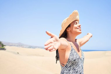 Güneş banyosu yapan genç ve güzel bir kadın. Maspalomas Kumulları 'nda yaz eşofmanı giyiyor.