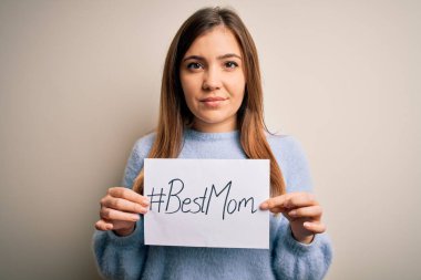 Elinde en iyi anne mesajı olan genç ve güzel bir kadın anneler gününü akıllı bir ifadeyle kutluyor ve ciddi düşünüyor.