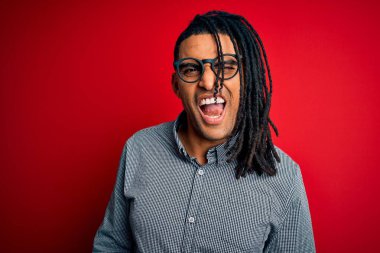 Rastgele gömlek giyen, gözlüklü, seksi bir ifadeyle kameraya bakan, neşeli ve mutlu yüzlü Afro-Amerikan genç adam..