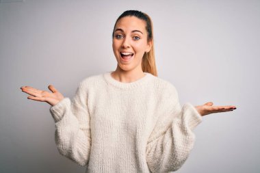 Mavi gözlü, genç, sarışın bir kadın beyaz arka plan üzerine gündelik süveter giyip çılgınlığı kutluyor ve başarıya hayret ediyor. Kolları havada ve gözleri açık, heyecanlı bir şekilde çığlık atıyor. Kazanan konsept