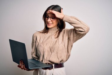 İzole edilmiş beyaz arka plan üzerinde dizüstü bilgisayar kullanan genç ve güzel esmer bir kadın. Elleri başının üstünde, utanç ve şaşkınlık dolu, sinirli ve hayal kırıklığına uğramış bir halde. Hata için korku ve üzüntü.