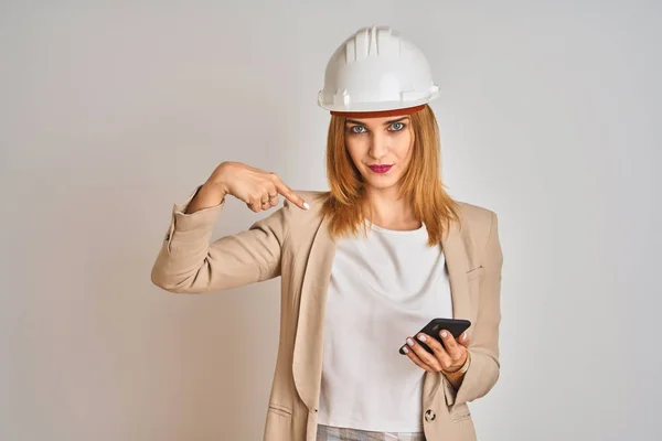 Junge Kaukasische Ingenieurin Mit Smartphone Und Schutzhelm Mit Überraschendem Gesicht — Stockfoto