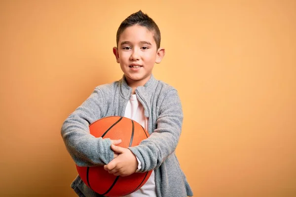 Jovem Garoto Brincando Com Bola Basquete Sobre Fundo Amarelo Isolado — Fotografia de Stock