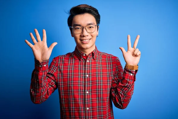 Молодий Вродливий Китайський Чоловік Одягнений Повсякденну Сорочку Окуляри Синьому Фоні — стокове фото