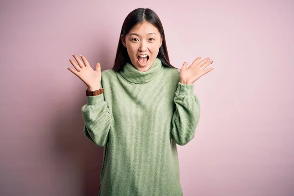 녹색의 스웨터를 아리따운 아시아 팔을들고 성공을 축하하는 음악에 모습을 — 스톡 사진