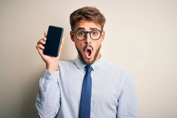 Jovem Empresário Segurando Smartphone Sobre Fundo Branco Isolado Assustado Choque — Fotografia de Stock
