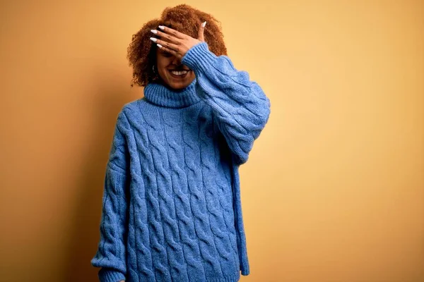 青いタートルネックのセーターを着て 驚きの目をカバー顔に手で笑って巻き毛を持つ若い美しいアフリカ系アメリカ人アフロ女性 ブラインドコンセプト — ストック写真