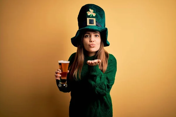 聖人の公園の日にビールの緑の帽子を飲むガラスを身に着けている若い美しい女性は 空気中の手でキスを吹いてカメラを見て美しく セクシーであること 愛の表現 — ストック写真