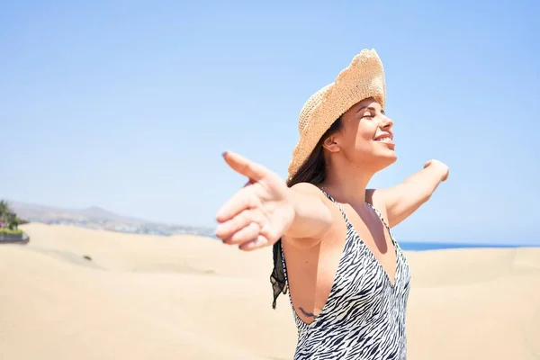 若いです美しいです女性日光浴とともにオープン腕身に着けています夏の水着でMaspalomas砂丘Bech — ストック写真