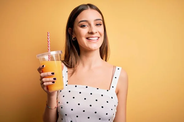 Junge Schöne Brünette Frau Trinkt Gesunden Orangensaft Auf Gelbem Hintergrund — Stockfoto