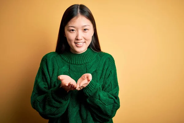 Молодая Красивая Азиатская Женщина Зеленом Зимнем Свитере Желтом Изолированном Фоне — стоковое фото
