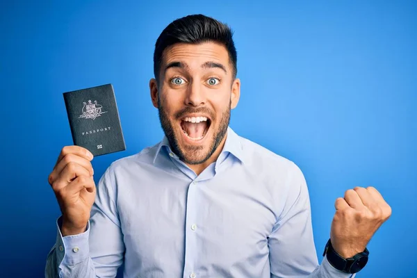 Młody Przystojny Turysta Trzyma Australia Australijski Paszport Niebieskim Tle Krzycząc — Zdjęcie stockowe