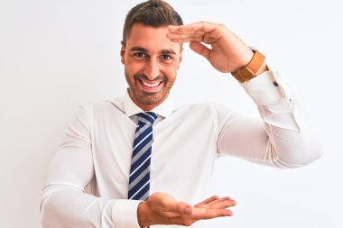 Yakışıklı, zarif ve soyutlanmış bir iş adamı. Elleriyle büyük ve büyük bir işaret, ölçü sembolü gösteriyor. Kameraya bakıp gülümsüyor. Ölçüm konsepti.