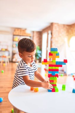 Güzel çocuk anaokulunda inşaat bloklarıyla oynuyor.