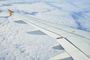 Pencere uçağından bulutlu bir manzara, bulutlu bir gökyüzünde kanat düzlemi manzarası