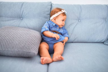 Evdeki kanepede uzanmış sevimli bir bebek. Yeni doğmuş bebek rahatlıyor ve dinleniyor.