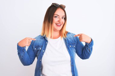 Beautiful woman wearing denim shirt standing over isolated white background looking confident with smile on face, pointing oneself with fingers proud and happy.