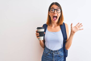 Güzel kızıl saçlı, sırt çantası takan ve kahveyi götüren mutlu ve heyecanlı bir öğrenci. Kazanan ifade zaferi büyük bir gülümsemeyle kutluyor ve ellerini kaldırıyor.