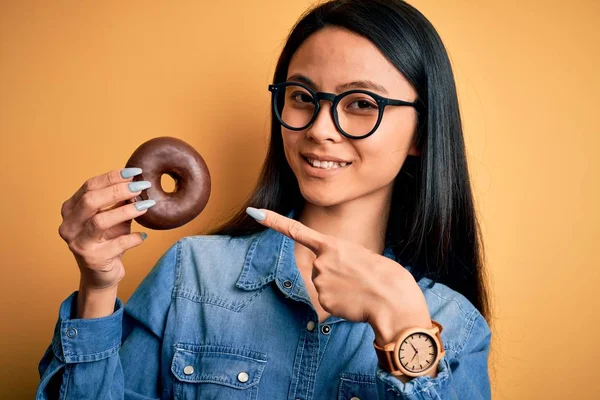 Jonge Mooie Chinese Vrouw Met Chocolade Donut Geïsoleerde Gele Achtergrond — Stockfoto