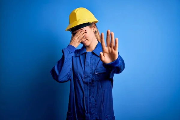 파란색 아름다운 노동자 헬멧을 손으로 채슬프고 두려운 표정으로 행동하는 멈추었습니다 — 스톡 사진