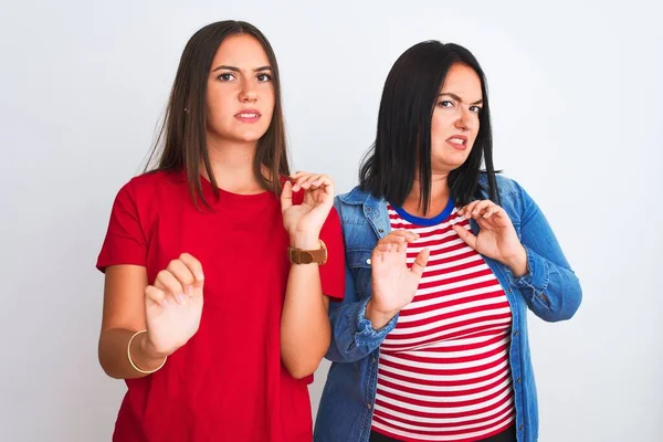 Young beautiful women wearing casual clothes standing over isolated white background disgusted expression, displeased and fearful doing disgust face because aversion reaction. With hands raised. Annoying concept.