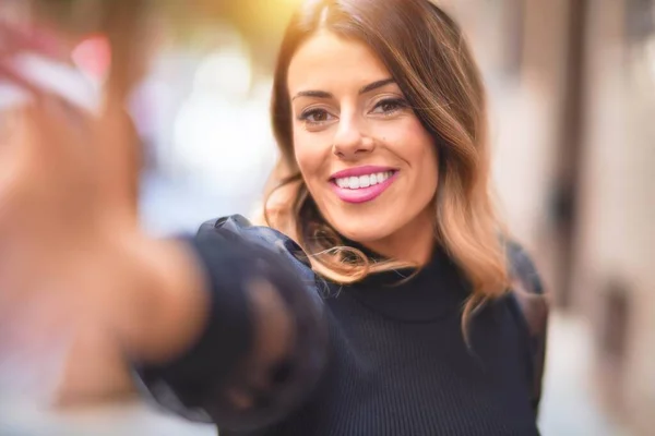 Young beautiful woman smiling happy and confident. Standing make selfie by camera at town street