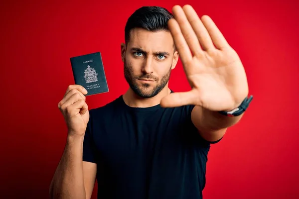 Joven Turista Guapo Sosteniendo Canada Pasaporte Canadiense Sobre Fondo Rojo —  Fotos de Stock