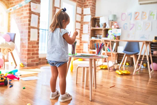 若いです美しいですブロンド女の子楽しいです学校でおもちゃで遊びます幼稚園 笑顔幸せな絵で鉛筆色とともに自宅 — ストック写真