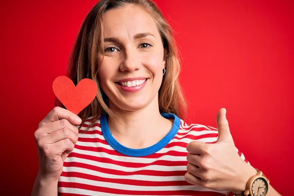 Junge Schöne Blonde Frau Hält Papierherz Das Über Isoliertem Rotem — Stockfoto