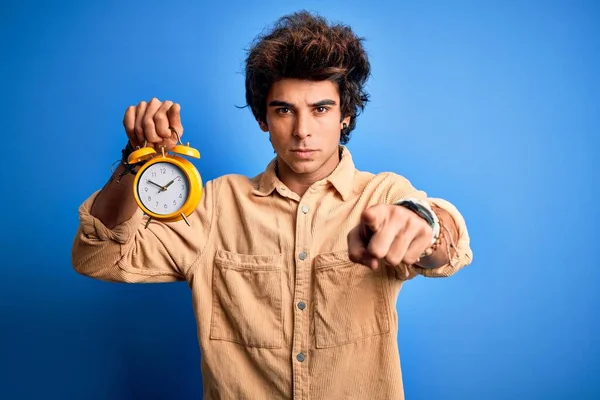 Young Handsome Man Holding Alarm Clock Standing Isolated Blue Background — Stok fotoğraf
