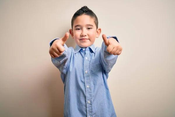 小男孩穿着文雅的衬衫 站在孤独的背景下 称赞他用手做了积极的手势 微笑着竖起大拇指 为成功感到高兴 赢的手势 — 图库照片