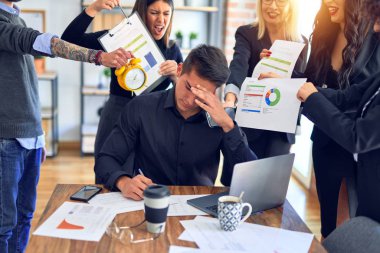 Group of business workers working together. Partners stressing one of them at the office