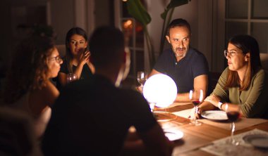 Güzel bir aile akşam yemeğinde terasta konuşuyor ve gülümsüyor