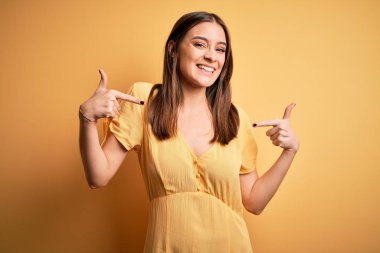 Sarı arka planda dikilen sıradan bir elbise giyen genç, güzel, esmer bir kadın. Kendine güvenen, yüzünde gülümseme olan, kendini gururlu ve mutlu gösteren bir kadın..